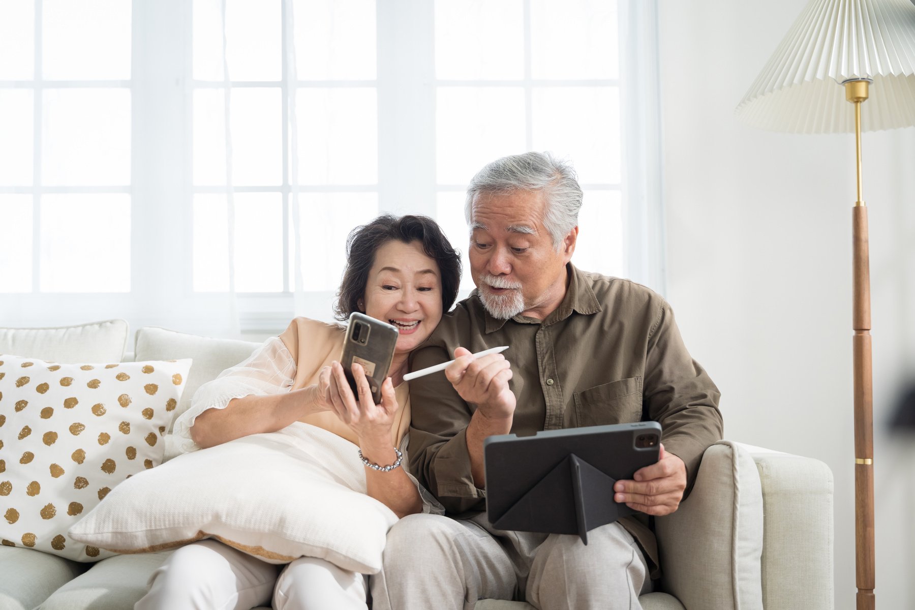 Senior Couple Using Phone and Tablet